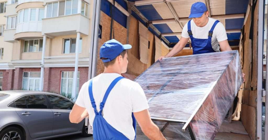 A white glove delivery crew unloading furniture from a truck